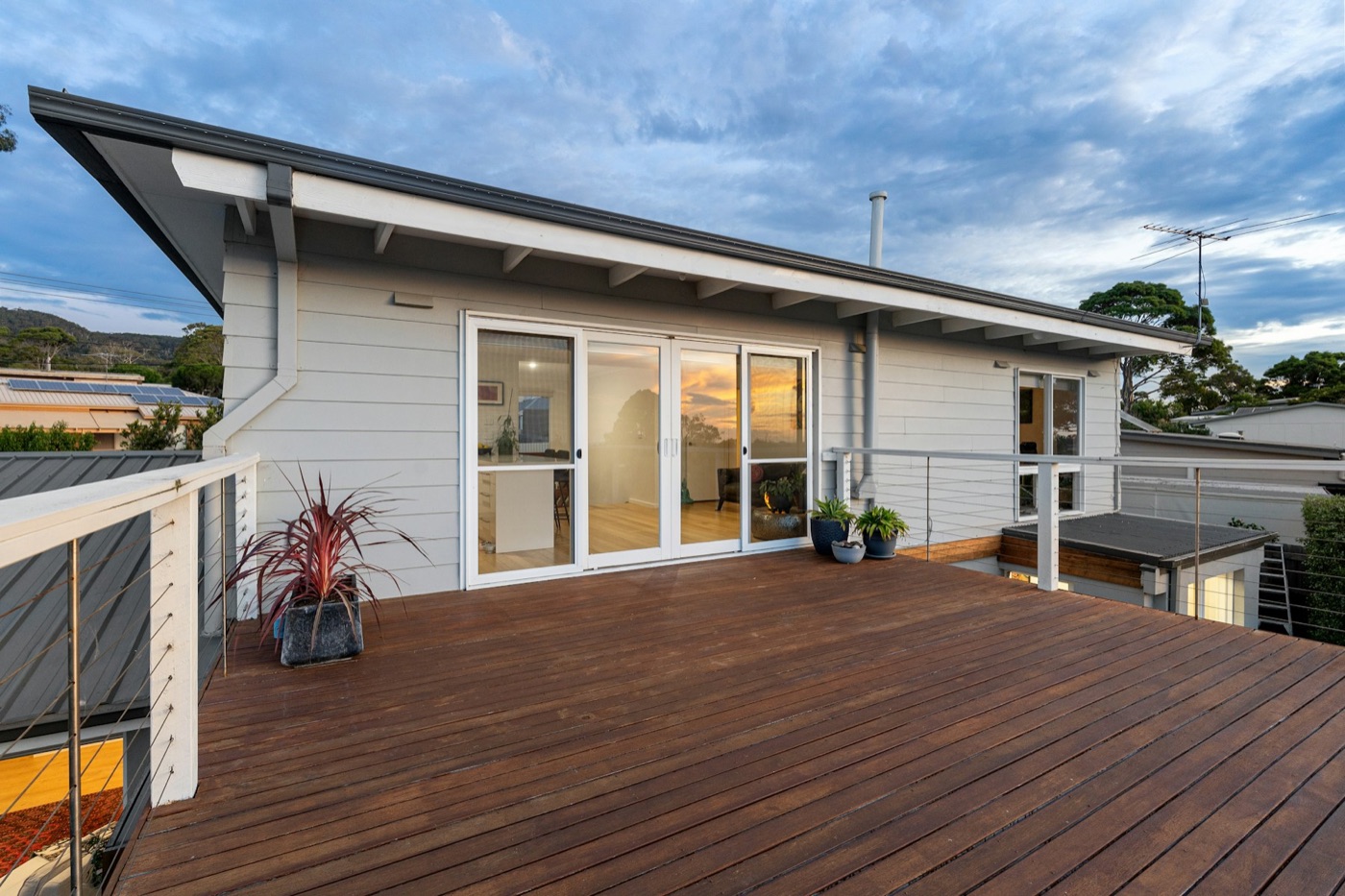 Second-storey weatherboard addition with hardwood deck at dusk